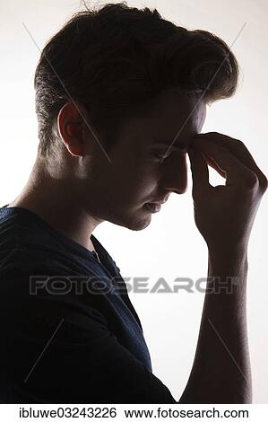 Stock Photograph - "Pensive young man, backlit, Mannheim, Baden-Wurttemberg, Germany, Europe". Fotosearch