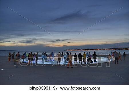 "People at the Monument to the Sun, Pozdrav Suncu, by architect Nikole Basica, at dusk, Zadar, Dalmatia, Croatia, Europe" View Large Photo Image Stock Photo - "People at the Monument to the Sun, Pozdrav Suncu, by architect Nikole Basica, at dusk, Zadar, Dalmatia, Croatia, Europe". Fotosearch