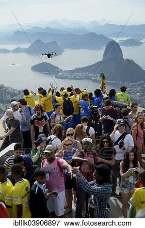 Stock Photo - "People cheering in the direction of a drone with cameras, Octopoter, on the observation deck in front of the Christ the Redeemer statue, Cristo Redentor, on Corcovado Mountain, Rio de Janeiro, Rio de Janeiro State, Brazil, South America". Fotosearch