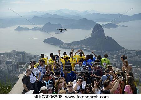 "People cheering in the direction of a drone with cameras, Octopoter, on the observation deck in front of the Christ the Redeemer statue, Cristo Redentor, on Corcovado Mountain, Rio de Janeiro, Rio de Janeiro State, Brazil, South America" View Large Photo Image Stock Photograph - "People cheering in the direction of a drone with cameras, Octopoter, on the observation deck in front of the Christ the Redeemer statue, Cristo Redentor, on Corcovado Mountain, Rio de Janeiro, Rio de Janeiro State, Brazil, South America". Fotosearch