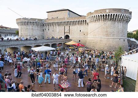 Picture - "People dancing in the festival grounds in front of Fortress Rocca Roveresca, Summer Jamboree, Rock 'n' Roll Festival, Senigallia, Province of Ancona, Marche, Italy, Europe". Fotosearch