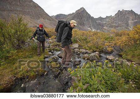 "People hiking in arctic or subalpine tundra, crossing a creek, Indian summer, Tombstone Mountains Territorial Park, Yukon Territory, Canada, North America" View Large Photo Image Stock Photo - "People hiking in arctic or subalpine tundra, crossing a creek, Indian summer, Tombstone Mountains Territorial Park, Yukon Territory, Canada, North America". Fotosearch