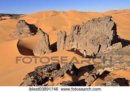 Stock Photograph - "People hiking in the sand dunes and rocks of Moul Naga, Tadrart, Tassili N'Ajjer National Park, Unesco World Heritage Site, Sahara, Algeria, Africa". Fotosearch