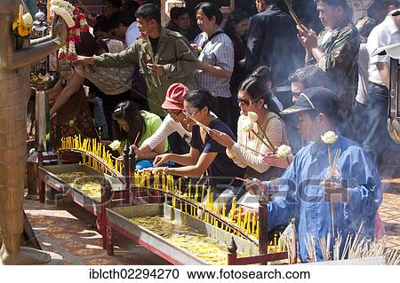 Stock Image - "People lighting candles and praying, Wat Phra That Doi Suthep temple complex, Thailand, Asia". Fotosearch