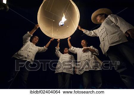 Picture - "People releasing a Kongming lantern or sky lantern for luck during the Loi Krathong or Loy Gratong Festival, Chiang Mai, Northern Thailand, Thailand, Asia". Fotosearch