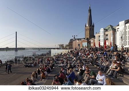 "People sitting on a flight of steps in the evening sun, Burgplatz square with St Lambertus church, historic center, Dusseldorf, Rhineland, North Rhine-Westphalia, Germany, Europe" View Large Photo Image Picture - "People sitting on a flight of steps in the evening sun, Burgplatz square with St Lambertus church, historic center, Dusseldorf, Rhineland, North Rhine-Westphalia, Germany, Europe". Fotosearch