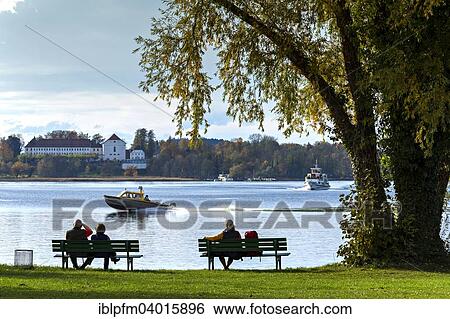 "People sitting on benches watching a Taxi boat, Fraueninsel, Chiemsee, Chiemgau, Upper Bavaria, Deutschland" View Large Photo Image Stock Photograph - "People sitting on benches watching a Taxi boat, Fraueninsel, Chiemsee, Chiemgau, Upper Bavaria, Deutschland". Fotosearch