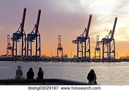 "People sitting on the shore in front of gantry cranes, Container Terminal Burchardkai, Hamburg-Port, Hamburg, Hamburg, Germany, Europe" View Large Photo Image Stock Photo - "People sitting on the shore in front of gantry cranes, Container Terminal Burchardkai, Hamburg-Port, Hamburg, Hamburg, Germany, Europe". Fotosearch