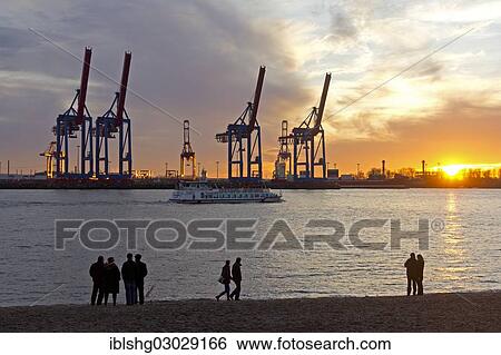 Stock Photograph - "People standing on the shore in front of gantry cranes, Container Terminal Burchardkai, Hamburg-Port, Hamburg, Hamburg, Germany, Europe". Fotosearch