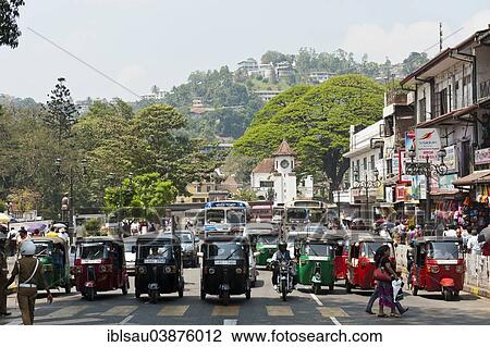 "People walk across the main road, tuk-tuks waiting in a row, Kandy, Sri Lanka, Asia" View Large Photo Image Stock Image - "People walk across the main road, tuk-tuks waiting in a row, Kandy, Sri Lanka, Asia". Fotosearch
