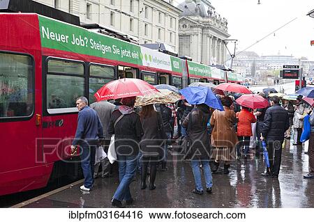 "People with umbrellas boarding a tram in Kornhausplatz square, Bern, Canton of Bern, Switzerland, Europe" View Large Photo Image Stock Photograph - "People with umbrellas boarding a tram in Kornhausplatz square, Bern, Canton of Bern, Switzerland, Europe". Fotosearch