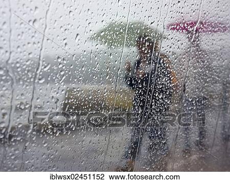 Stock Image - People with umbrellas in the rain. Fotosearch