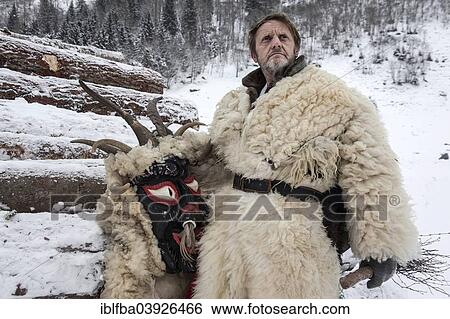 Stock Photograph - "Perchtentreiben, wild hunt, """"Toifi"""", a perchta character with a traditional mask during a rest, Rauris, Salzburg State, Austria, Europe". Fotosearch