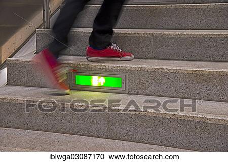 "Person rushing up a public staircase with a green illuminated emergency exit sign, Germany, Europe" View Large Photo Image Stock Image - "Person rushing up a public staircase with a green illuminated emergency exit sign, Germany, Europe". Fotosearch