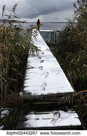 "Person standing at the end of a snow covered pier, Chiemgau, Upper Bavaria, Germany, Europe" View Large Photo Image Stock Photo - "Person standing at the end of a snow covered pier, Chiemgau, Upper Bavaria, Germany, Europe". Fotosearch