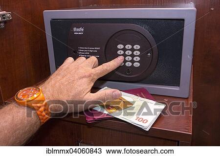 "Person typing a PIN into a closed safe, credit card, passports and cash lying in front of the safe, in a hotel room" View Large Photo Image Stock Image - "Person typing a PIN into a closed safe, credit card, passports and cash lying in front of the safe, in a hotel room". Fotosearch