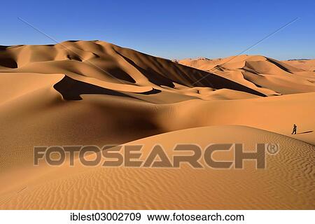 "Person walking on a sand dune, Sahara Desert, Immidir or Mouydir, Erg Mehejibad, Tamanrasset Province, Algeria, Africa" View Large Photo Image Stock Photo - "Person walking on a sand dune, Sahara Desert, Immidir or Mouydir, Erg Mehejibad, Tamanrasset Province, Algeria, Africa". Fotosearch