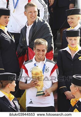 "Philipp Lahm with the trophy and Bastian Schweinsteiger, arrival of the German national team after their victory at the FIFA World Cup 2014 at Tegel, Berlin, Germany Airport" View Large Photo Image Stock Image - "Philipp Lahm with the trophy and Bastian Schweinsteiger, arrival of the German national team after their victory at the FIFA World Cup 2014 at Tegel, Berlin, Germany Airport". Fotosearch