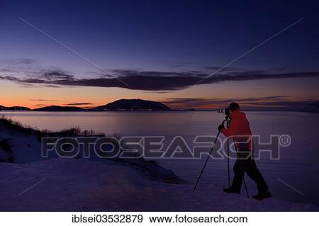 "Photographer in front of a fjord at Sunset, Sommeroya, Tromso, ‪Troms, Northern Norway, Norway, Europe" View Large Photo Image Stock Photo - "Photographer in front of a fjord at Sunset, Sommeroya, Tromso, ‪Troms, Northern Norway, Norway, Europe". Fotosearch