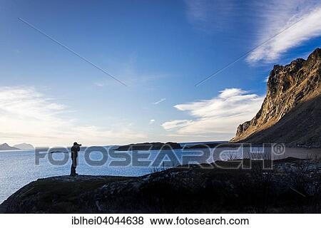 Stock Photo - "Photographer standing on a rock, Tangstad, Lofoten, Norway, Europe". Fotosearch