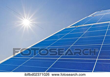 Stock Photograph - "Photovoltaic power plants against blue sky and bright sun, Nentmannsdorf, Saxony, Germany, Europe". Fotosearch