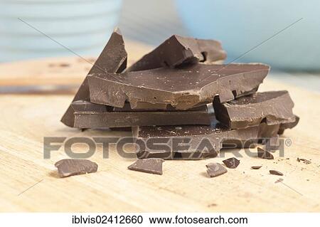 Pieces of broken dark chocolate stacked on a cutting board View Large Photo Image Stock Image - Pieces of broken dark chocolate stacked on a cutting board. Fotosearch