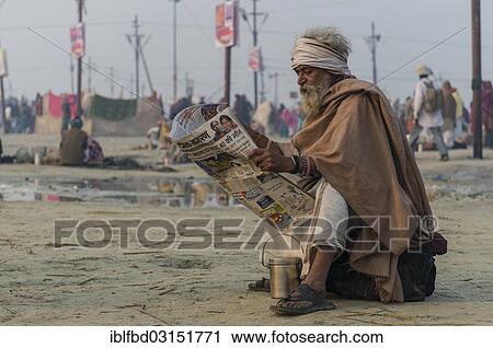Stock Image - "Pilgrim reading newspaper in the morning, during Kumbha Mela, Allahabad, Uttar Pradesh, India, Asia". Fotosearch