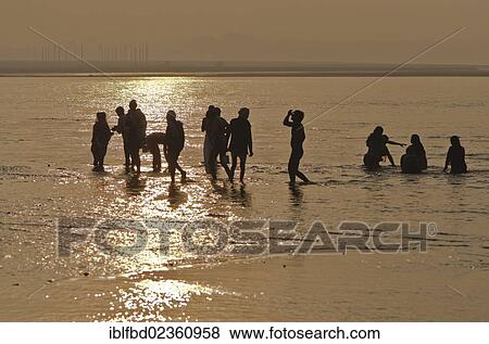 Stock Photo - "Pilgrims standing in the water at Sangam, the confluence of the holy rivers Ganges, Yamuna and Saraswati, Allahabad, India, Asia". Fotosearch