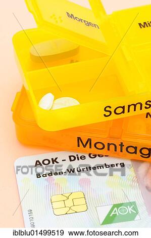 Stock Photo - Pill boxes with tablets and a health insurance card from AOK health insurance. Fotosearch