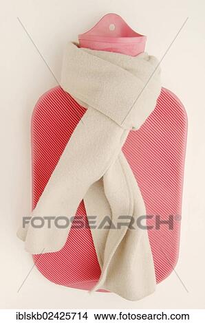 Picture - Pink hot water bottle with a winter scarf. Fotosearch