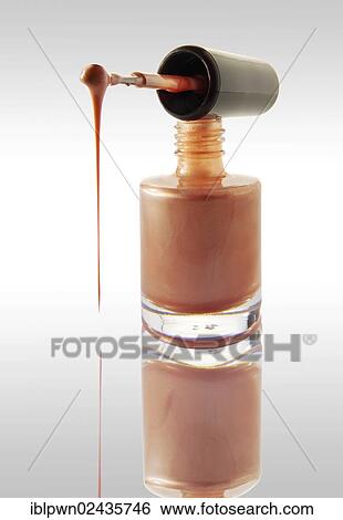 Stock Photograph - Pink nail varnish dripping from a nail varnish brush balanced on a nail varnish bottle. Fotosearch