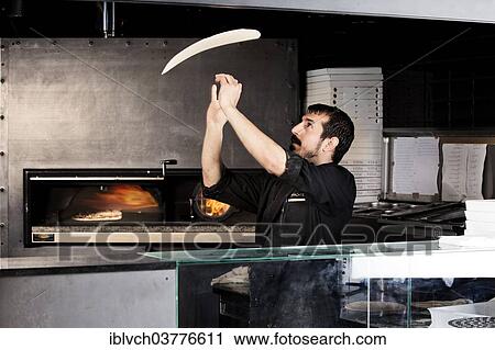 "Pizza baker preparing the pizza dough, pizza dough is being thrown into the air in front of the pizza oven" View Large Photo Image Stock Image - "Pizza baker preparing the pizza dough, pizza dough is being thrown into the air in front of the pizza oven". Fotosearch