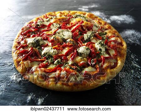 Stock Image - "Pizza topped with pesto, chicken and red peppers". Fotosearch