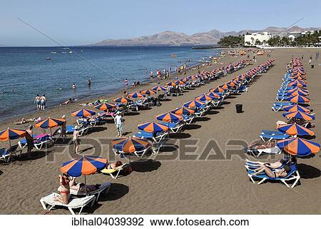 "Playa Blanca beach with parasols and sun loungers, behind the mountains of Los Ajaches, Puerto del Carmen, Lanzarote, Canary Islands, Spain, Europe" View Large Photo Image Stock Image - "Playa Blanca beach with parasols and sun loungers, behind the mountains of Los Ajaches, Puerto del Carmen, Lanzarote, Canary Islands, Spain, Europe". Fotosearch