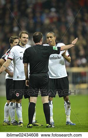 Stock Photo - "Players of Eintracht Frankfurt are discussing a decision with referee Marco Fritz, Allianz Arena, Munich, Bavaria, Germany, Europe". Fotosearch