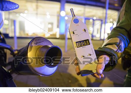 Picture - "Police control, policeman holding a noise level meter beside the exhaust of a motorcycle whose noise reduction device has been removed, Theodor-Heuss-Strasse, Stuttgart, Baden-Wuerttemberg, Germany, Europe". Fotosearch