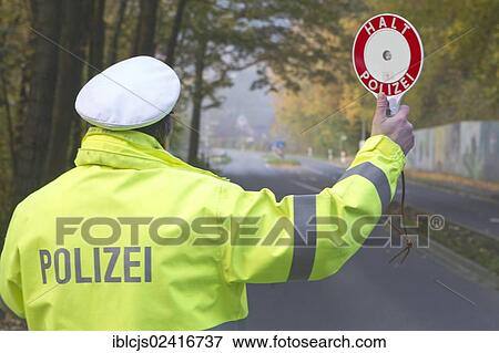 Policeman holding a signalling disc, lettering Halt, Polizei, German for Stop, Police, speed control, on 24/10/2012, Oberbergischer Kreis district, Lindlar, North Rhine-Westphalia, Germany, Europe View Large Photo Image Stock Photo - Policeman holding a signalling disc, lettering Halt, Polizei, German for Stop, Police, speed control, on 24/10/2012, Oberbergischer Kreis district, Lindlar, North Rhine-Westphalia, Germany, Europe. Fotosearch