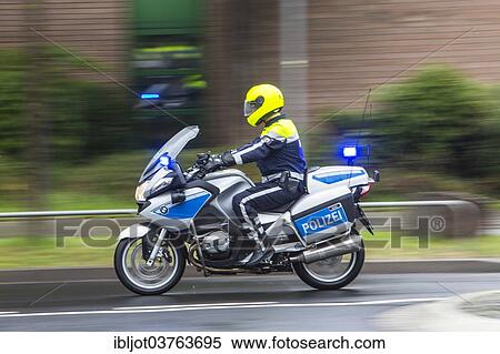 "Policeman wearing yellow a helmet on a motorcycle, police motorcycle patrol of the NRW Police riding with flashing blue lights during an emergency operation, Germany, Europe" View Large Photo Image Stock Photography - "Policeman wearing yellow a helmet on a motorcycle, police motorcycle patrol of the NRW Police riding with flashing blue lights during an emergency operation, Germany, Europe". Fotosearch