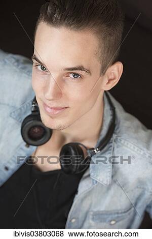 Portrait of a confident and carefree young adult male with earphones View Large Photo Image Stock Photo - Portrait of a confident and carefree young adult male with earphones. Fotosearch