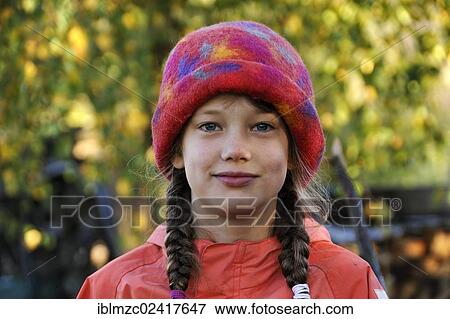 Portrait of a girl with braids, eight years old, wearing a colorful felt hat, Othenstorf, Mecklenburg-Western Pomerania, Germany, Europe View Large Photo Image Stock Photo - Portrait of a girl with braids, eight years old, wearing a colorful felt hat, Othenstorf, Mecklenburg-Western Pomerania, Germany, Europe. Fotosearch
