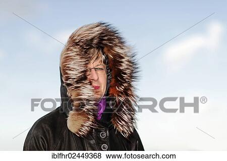 Stock Photo - "Portrait of a woman wearing a fur hood, strong wind, in autumn, Grevenbroich, North Rhine-Westphalia, Germany, Europe". Fotosearch
