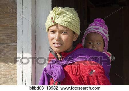"Portrait of a young local mother, carrying her child on her back, Nunthala, Solukhumbu District, Sagarmatha Zone, Nepal, Asia" View Large Photo Image Stock Image - "Portrait of a young local mother, carrying her child on her back, Nunthala, Solukhumbu District, Sagarmatha Zone, Nepal, Asia". Fotosearch