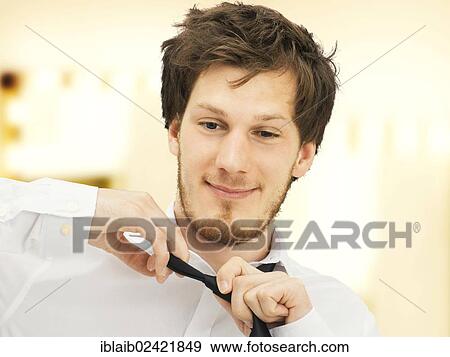 Portrait of a young man with a beard, taking off tie, smiling, relaxed View Large Photo Image Stock Photo - Portrait of a young man with a beard, taking off tie, smiling, relaxed. Fotosearch