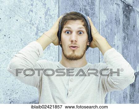 Portrait of a young man with a beard, woolly hat, standing in front of a wall, looking amazed View Large Photo Image Stock Photo - Portrait of a young man with a beard, woolly hat, standing in front of a wall, looking amazed. Fotosearch