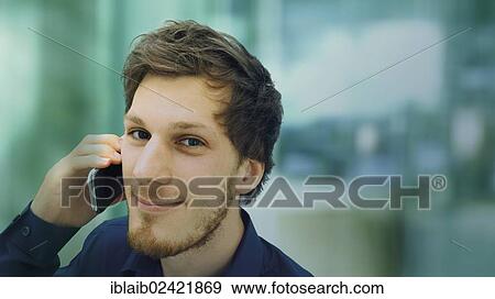 Portrait of a young man with a beard making a telephone call, smiling, relaxed View Large Photo Image Stock Photo - Portrait of a young man with a beard making a telephone call, smiling, relaxed. Fotosearch