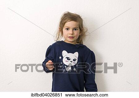 Stock Image - "Portrait, three-year-old girl with fair hair, blue sweater with the picture of a white cat". Fotosearch