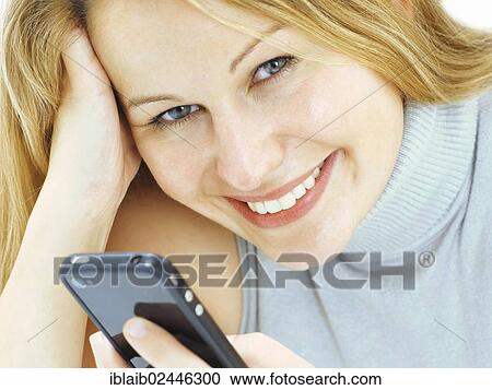 "Portrait, young woman holding a mobile phone, smiling" View Large Photo Image Stock Image - "Portrait, young woman holding a mobile phone, smiling". Fotosearch