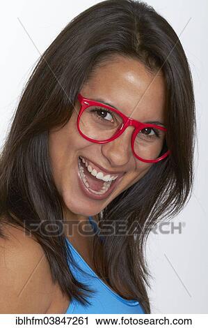 Stock Image - "Portrait, young woman with red glasses, laughing". Fotosearch