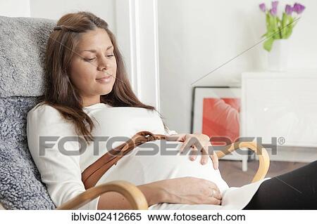 Pregnant woman holding hand on her stomach View Large Photo Image Stock Photography - Pregnant woman holding hand on her stomach. Fotosearch
