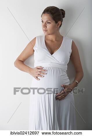 Pregnant woman holding hands on her stomach View Large Photo Image Stock Photo - Pregnant woman holding hands on her stomach. Fotosearch